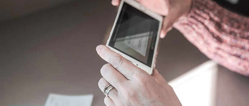 Woman capturing a check on her smartphone